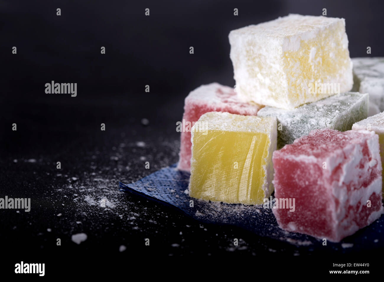 Turkish delight pieces on blue paper napkin over black background Stock Photo