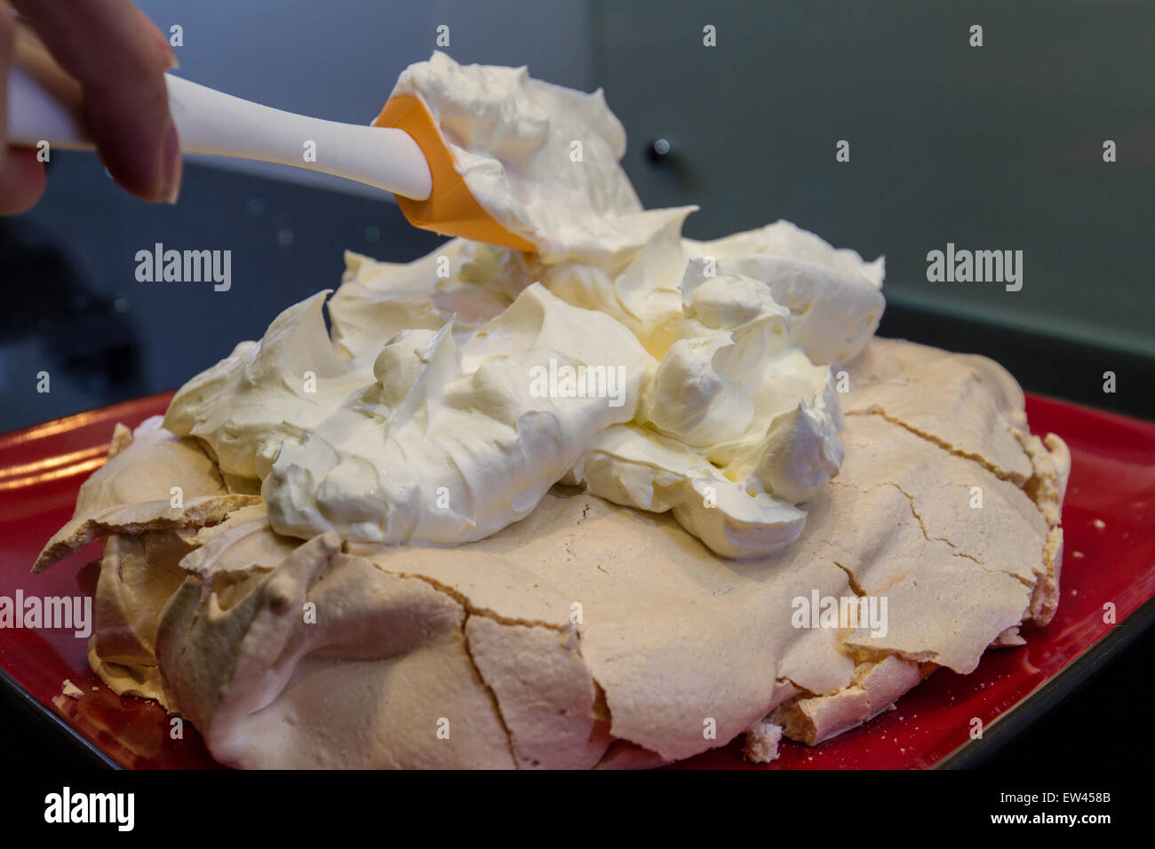 decorating a pavlova with cream Stock Photo