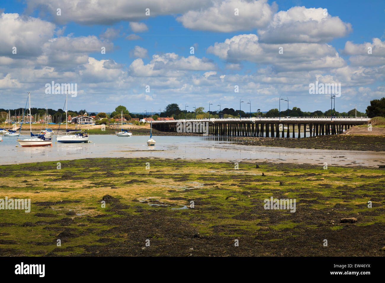 Distant view of the langstone bridge at low tide with moored yachts Stock Photo