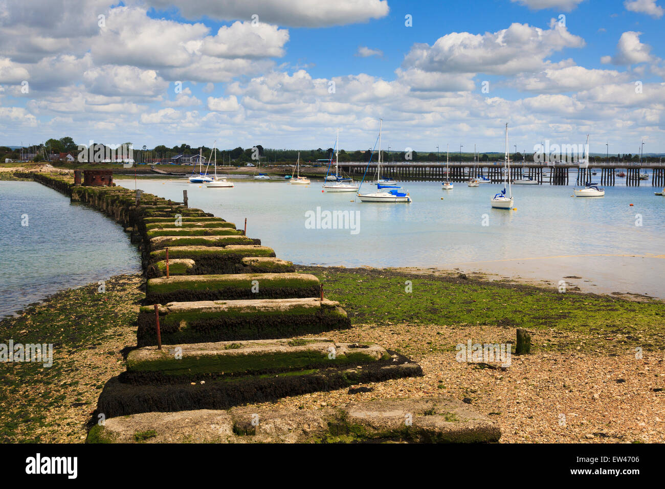 Remains of the supports to the old Hayling Billy railway across Langstone Harbour with the new bridge. Stock Photo