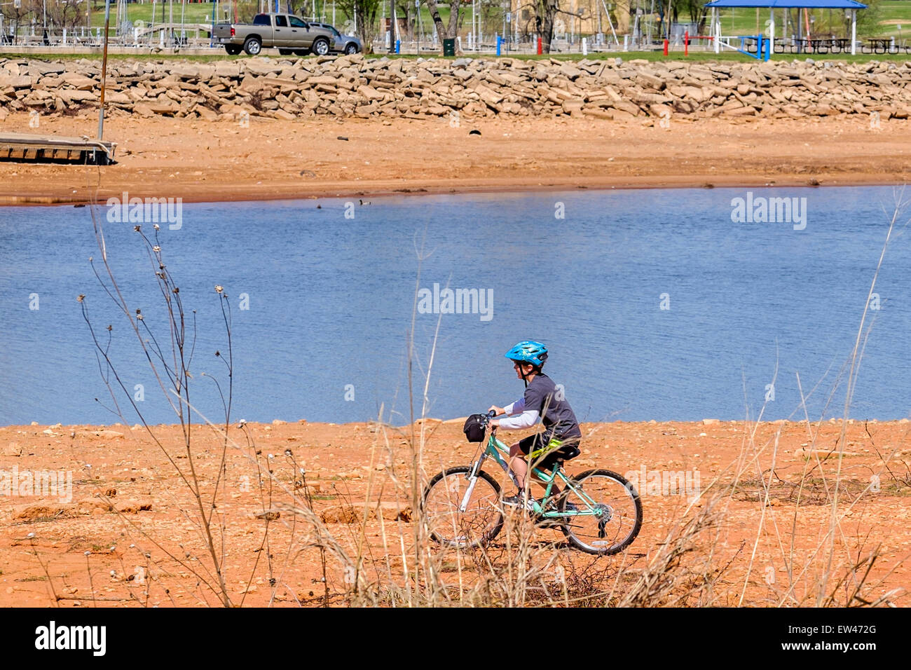 A boy rides his bicycle on a dry lake bed at Lake Hefner during a drought in Oklahoma City, Oklahoma, USA. Stock Photo