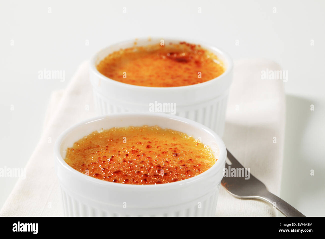 Creme brulee in white ramekins Stock Photo Alamy