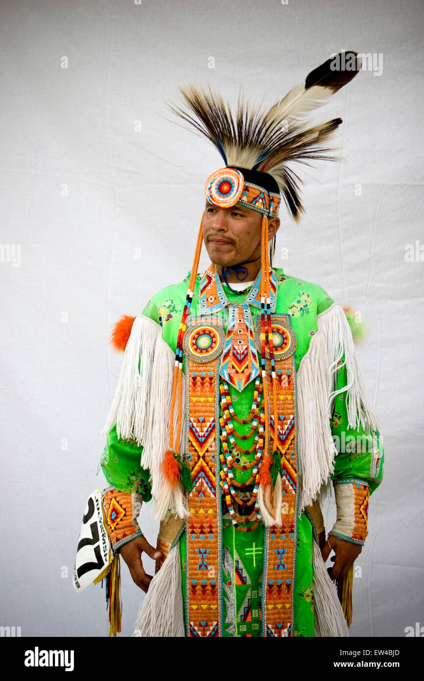 Portrait of a Native American man wearing an elaborate feather and bead ...