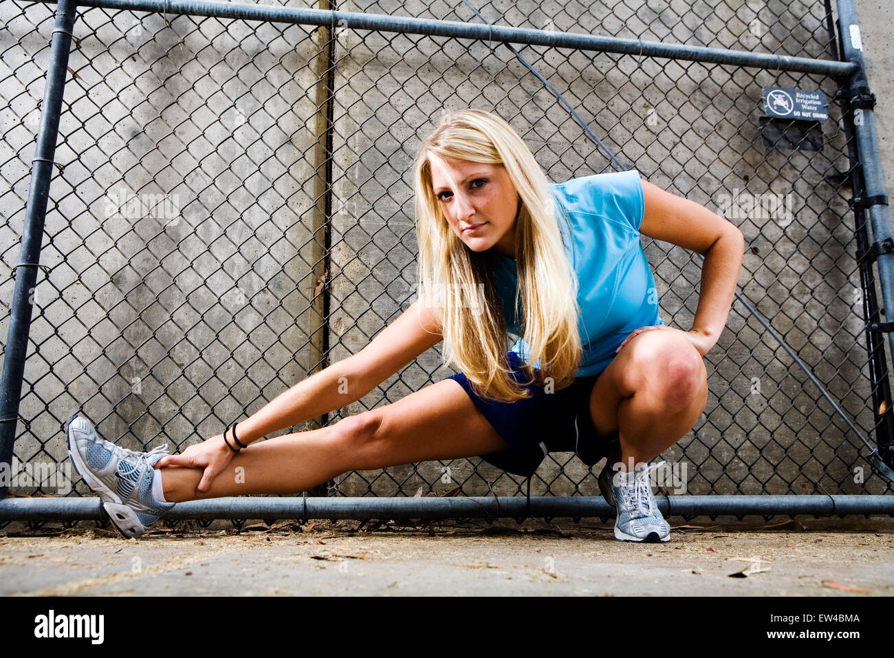 Blond woman stretches and prepares for a run San Diego California. Stock Photo