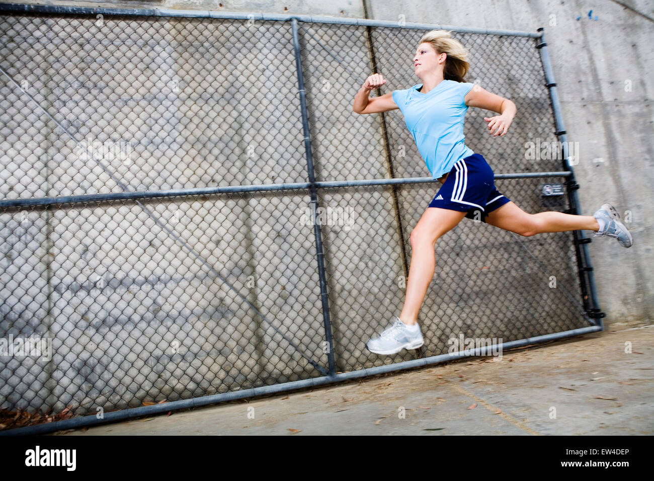 Blond woman running in an industrial area San Diego California. Stock Photo