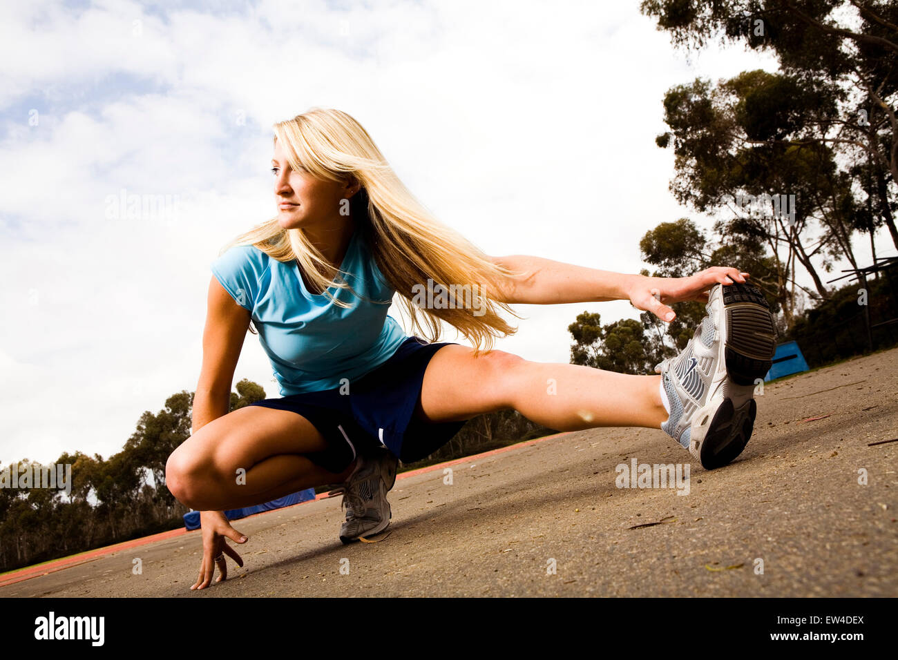 Blond woman stretches and prepares for a run San Diego California. Stock Photo