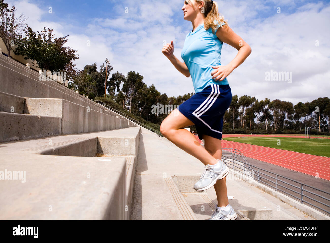 Blond woman running the stairs of a stadium San Diego California. Stock Photo