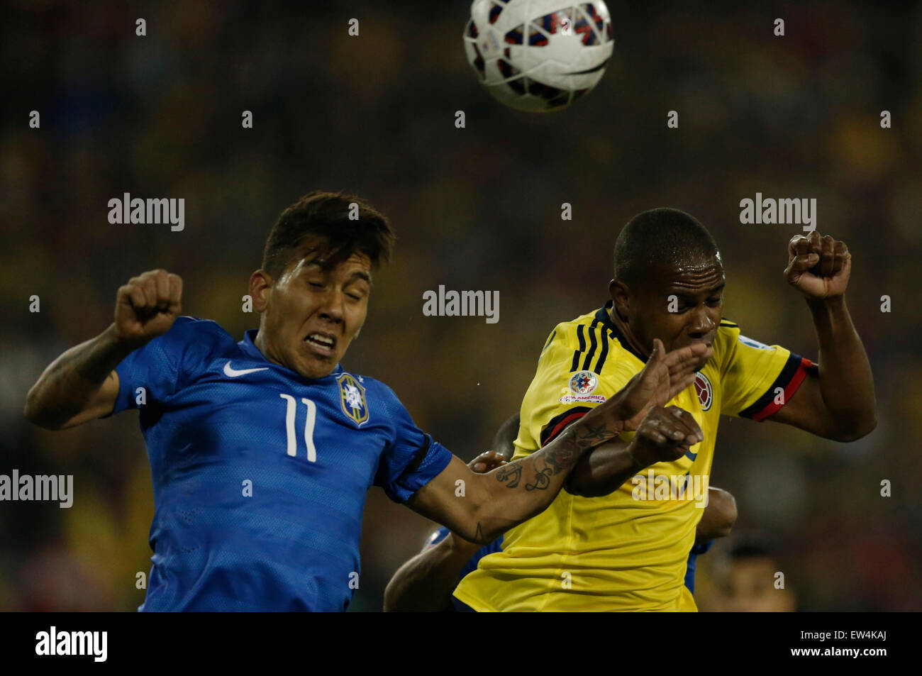 Santiago, Chile. 17th June, 2015. Roberto Firmino (L) of Brazil vies for the ball with Cristian Zapata of Colombia during the Group C match of the Copa America Chile 2015, at the Estadio Monumental, in Santiago, Chile, on June 17, 2015. Credit:  Guillermo Arias/Xinhua/Alamy Live News Stock Photo