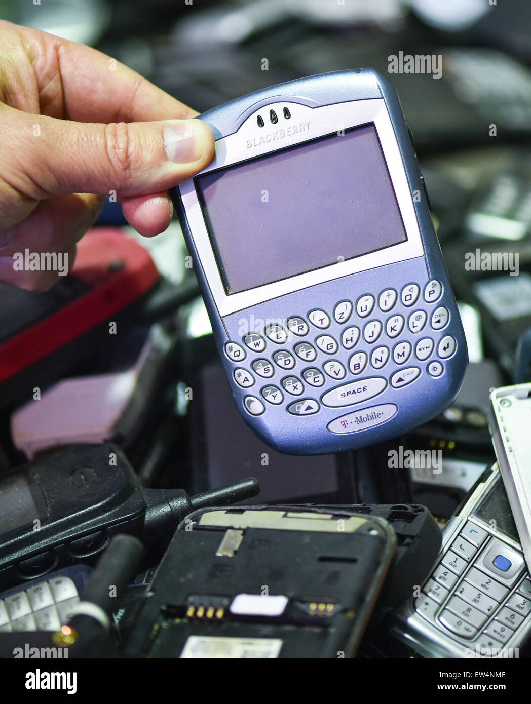 Luststadt, Germany. 27th May, 2015. A hand holds an old mobile phone in the recycling company ALBA in Luststadt, Germany, 27 May 2015. Photo: UWE ANSPACH/dpa/Alamy Live News Stock Photo