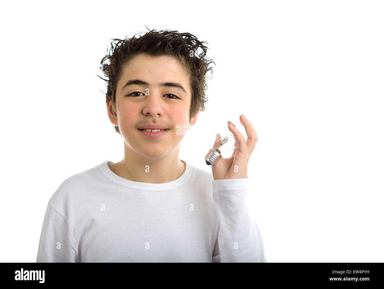 Handsome hispanic boy in white long sleeved t-shirt is holding a lightbulb in the same way as he's going to listen to it Stock Photo