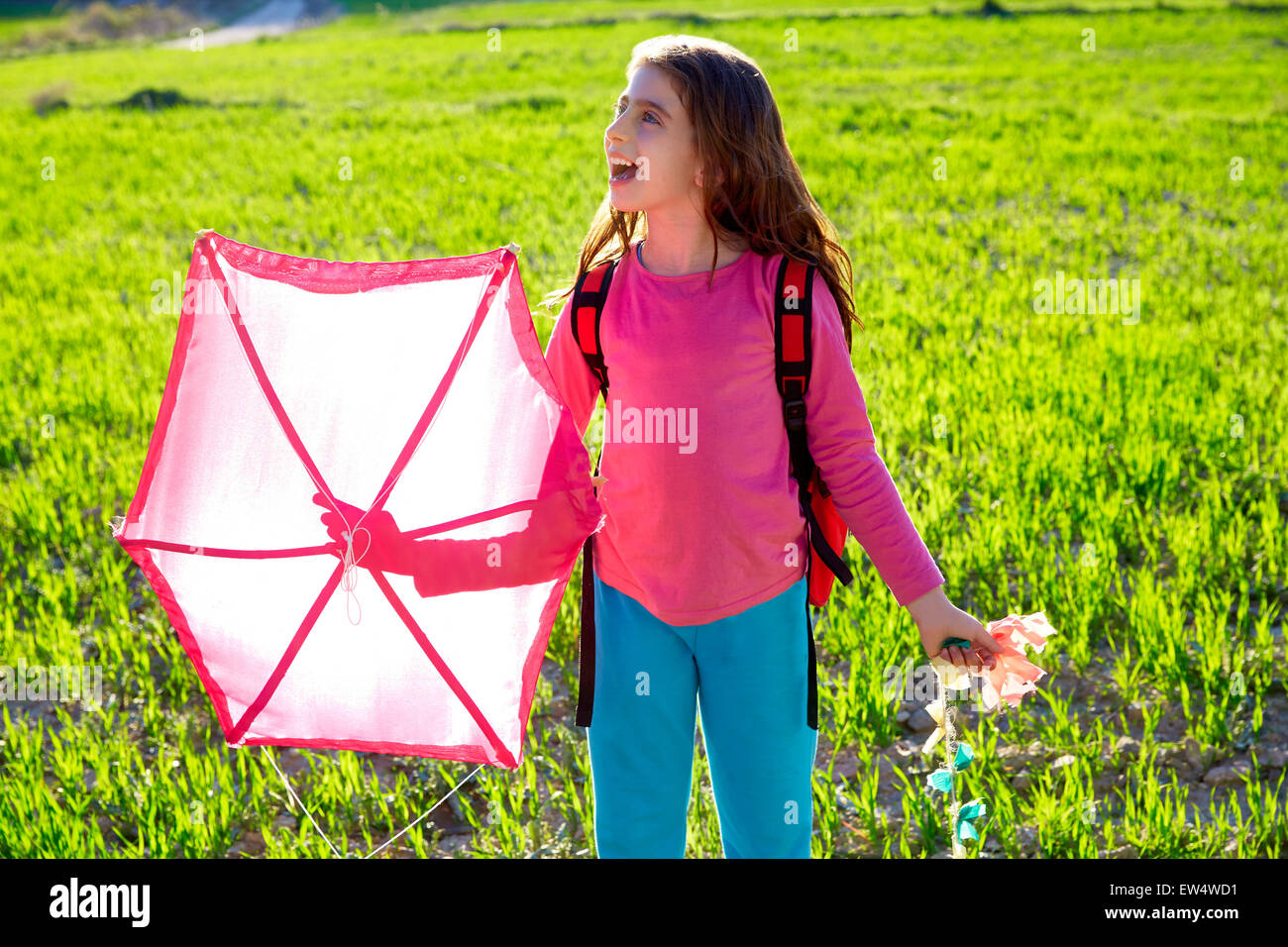 Kid girl holding pink kite traditional in spring on meadow Stock Photo