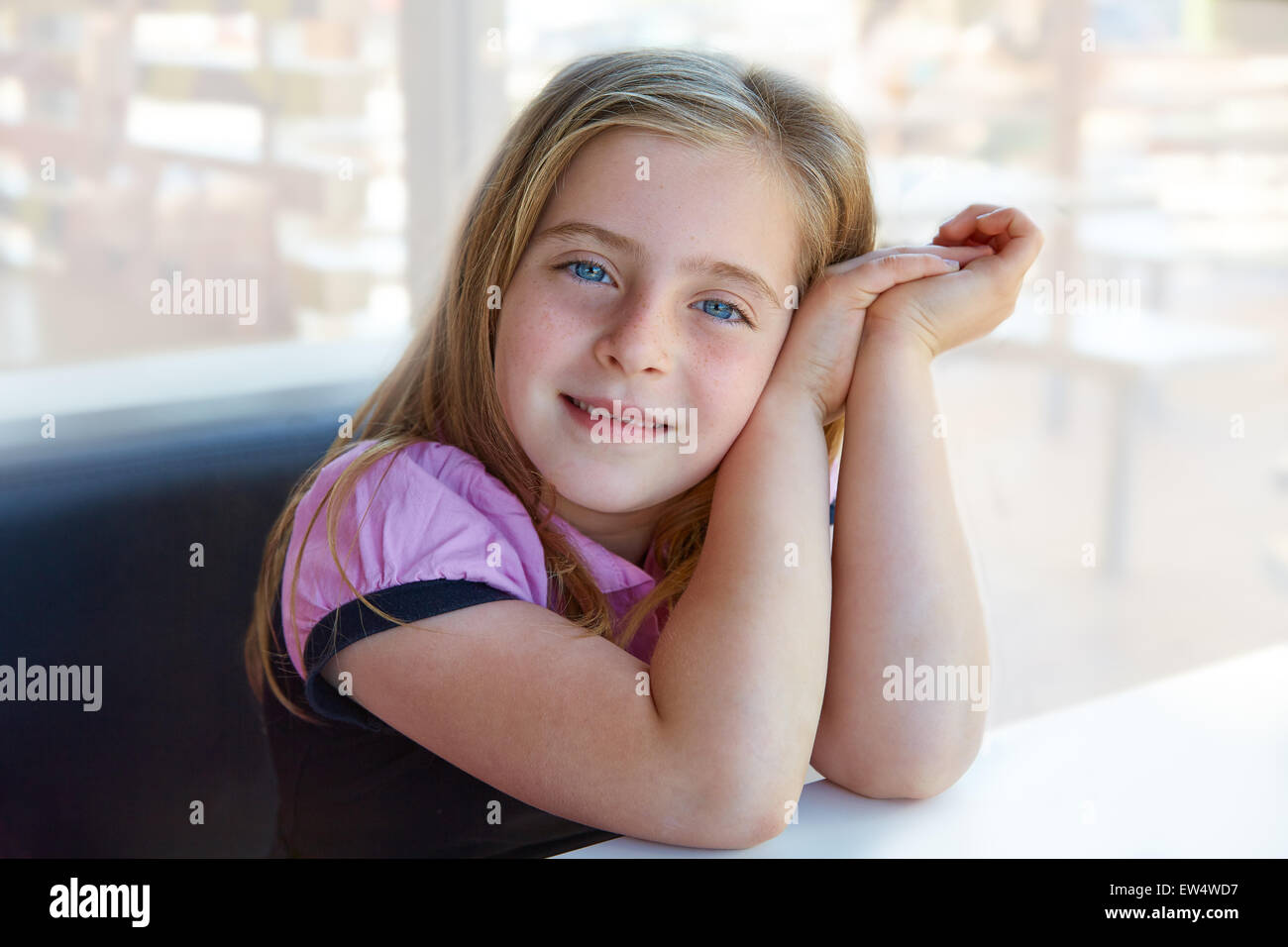 Blond relaxed happy kid girl expression blue eyes smiling Stock Photo