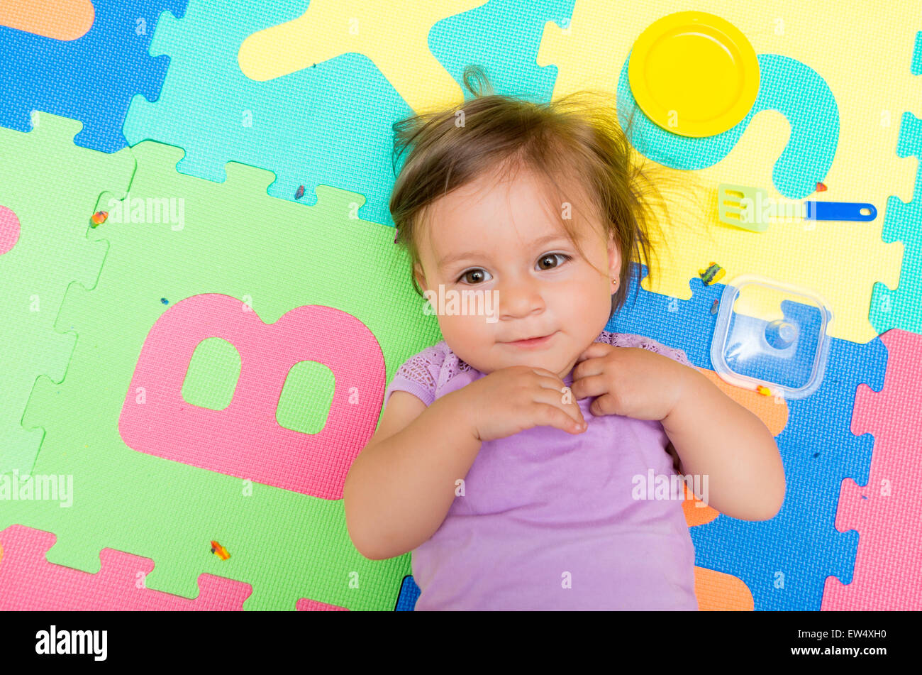 Adorable baby girl lying on floor mats Stock Photo Alamy