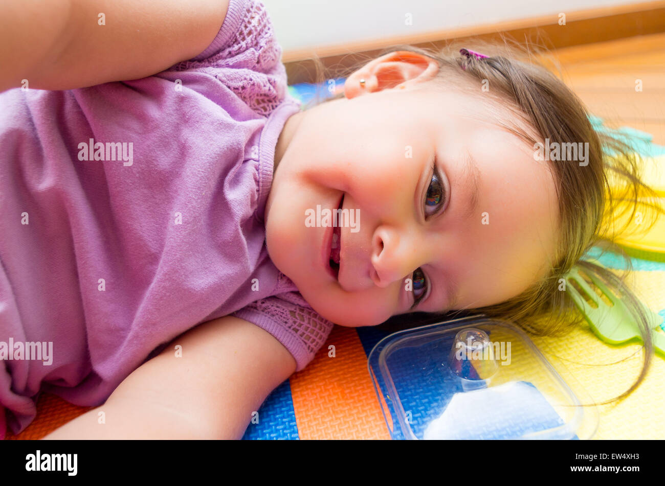 Adorable baby girl lying sideways Stock Photo