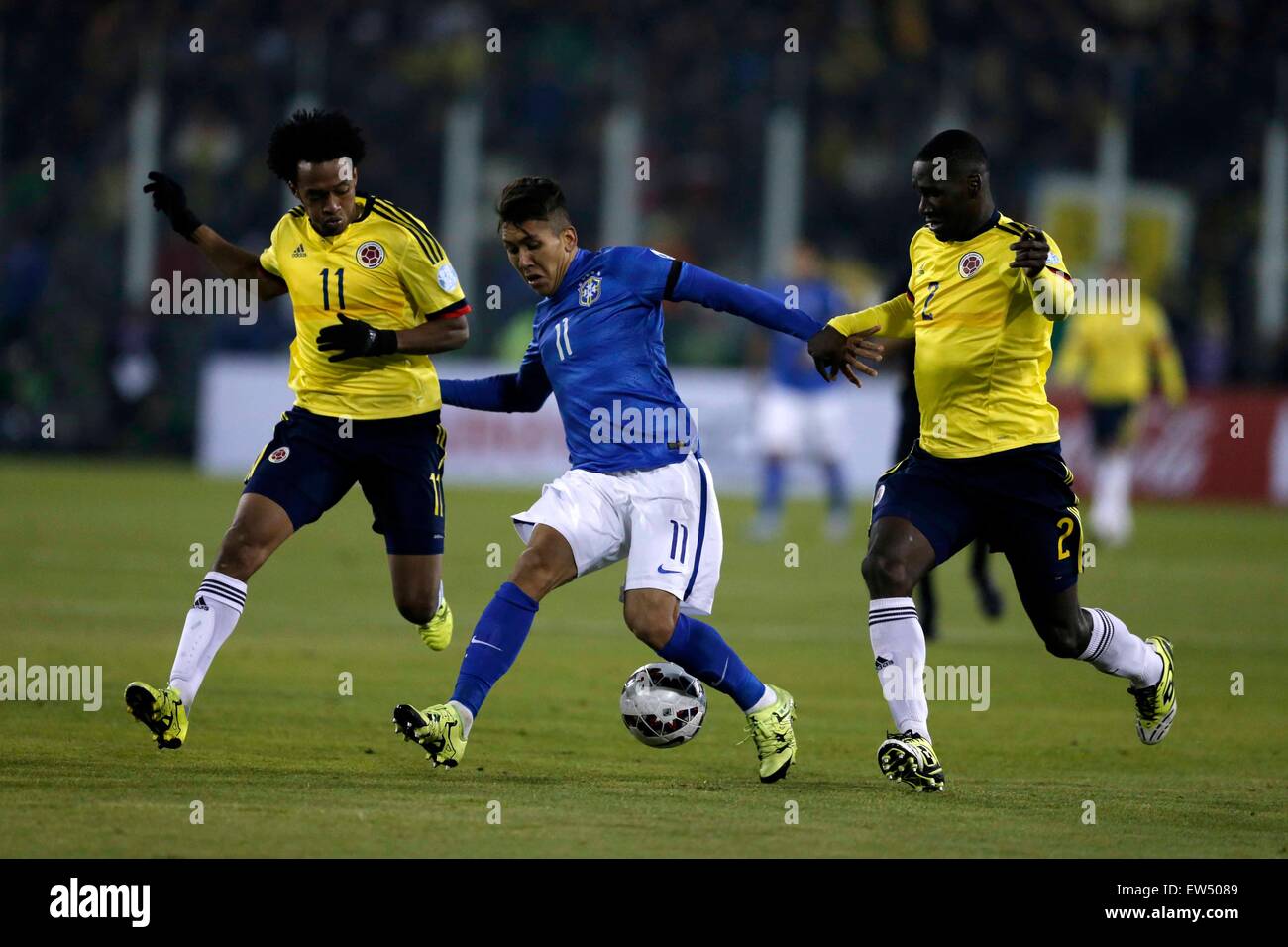 Santiago, Chile. 17th June, 2015. Roberto Firmino (C) of Brazil vies for the ball with Juan Cuadrado (L) and Cristian Zapata of Colombia during the Group C match of the Copa America Chile 2015 between Brazil and Colombia, at the Estadio Monumental, in Santiago, Chile, on June 17, 2015. Credit:  Guillermo Arias/Xinhua/Alamy Live News Stock Photo