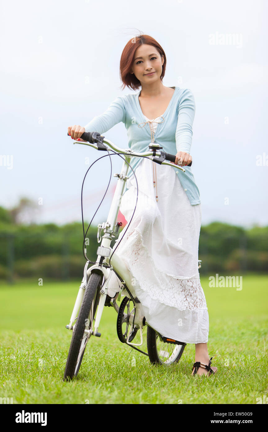Young woman riding a bike and smiling at the camera Stock Photo