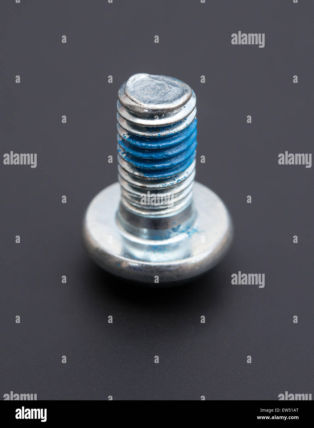 round head bolt with blue glue on a black background Stock Photo