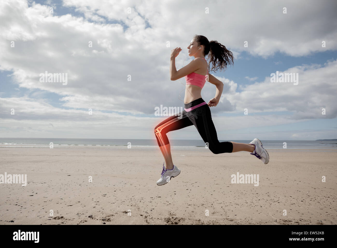 Highlighted leg bones of jogging woman on beach Stock Photo