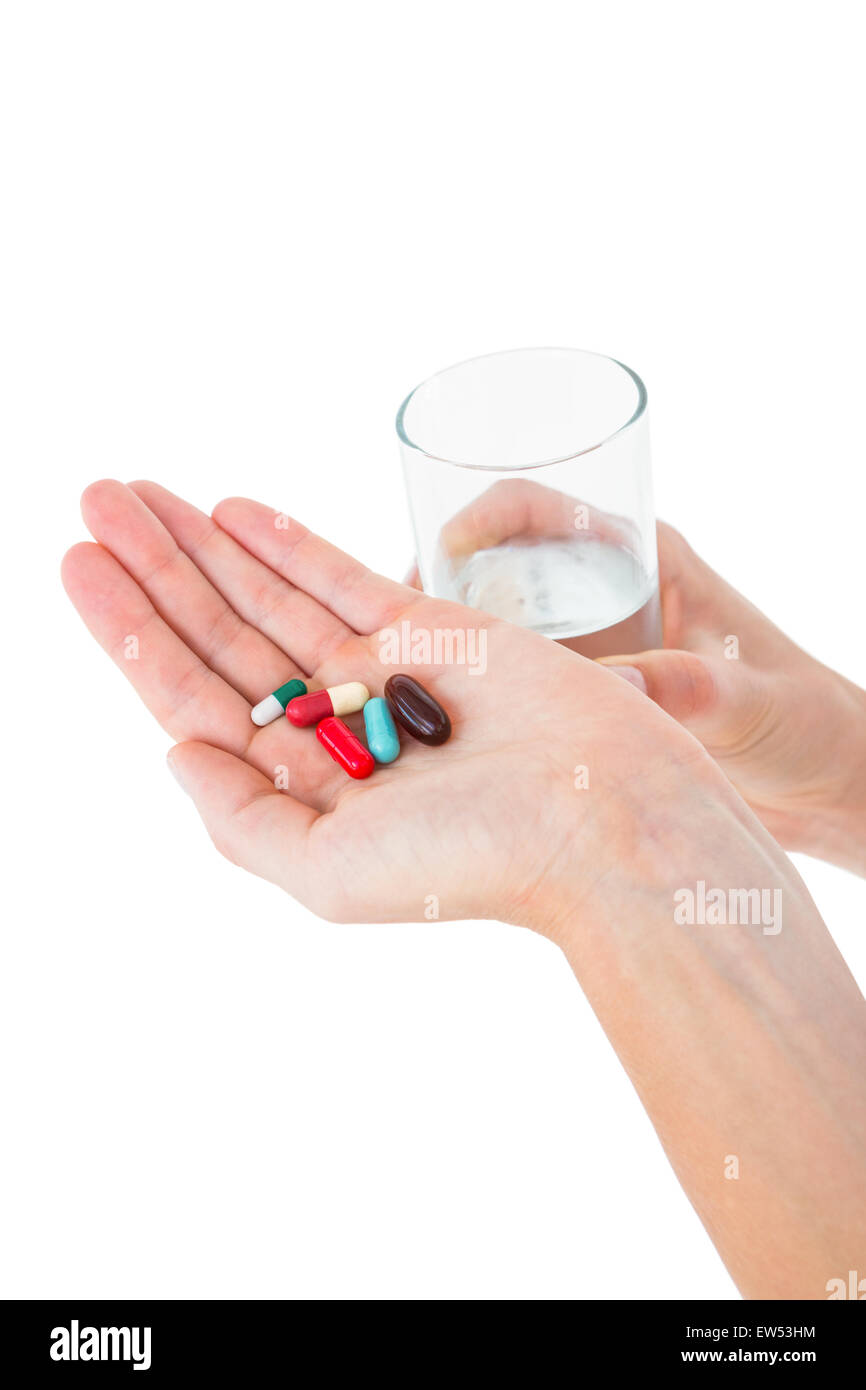 Woman holding batch of pills and glass of water Stock Photo