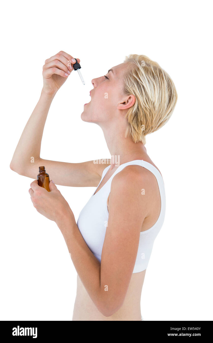 Fit blonde woman swallowing medicine Stock Photo - Alamy