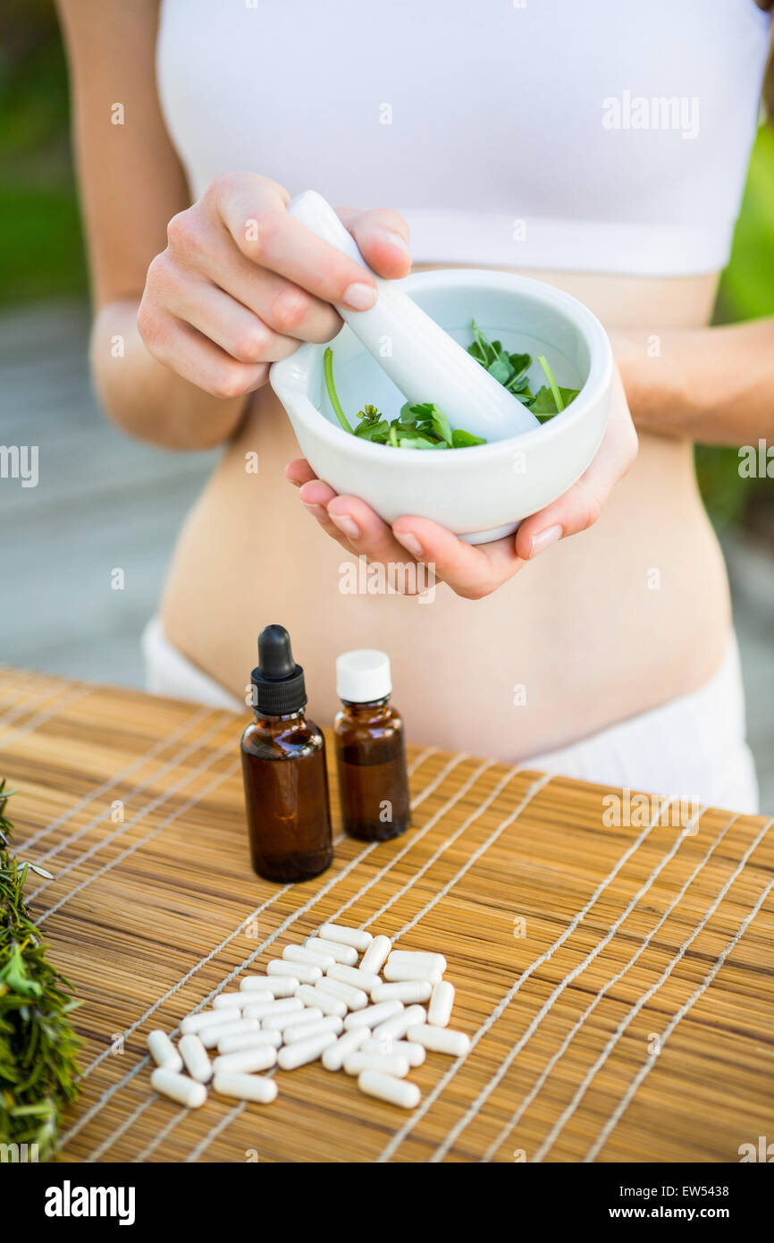 Happy blonde woman mixing herbs Stock Photo