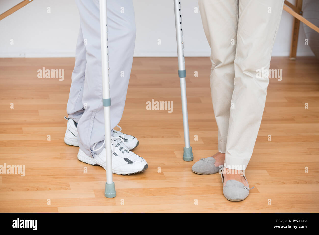 Doctor helping her patient walking with crutch Stock Photo Alamy