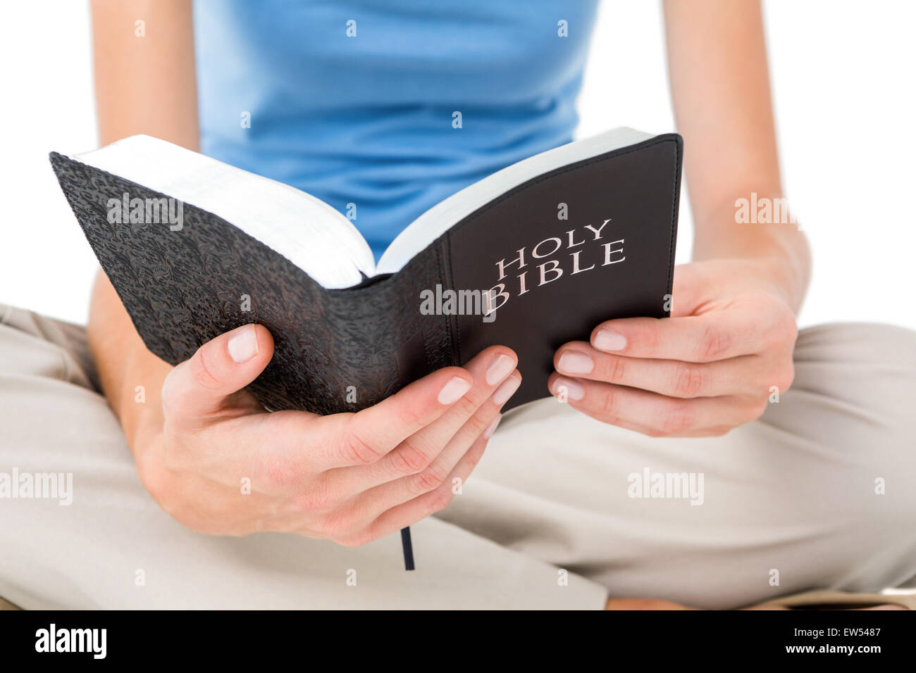 Woman sitting on the floor and reading bible Stock Photo
