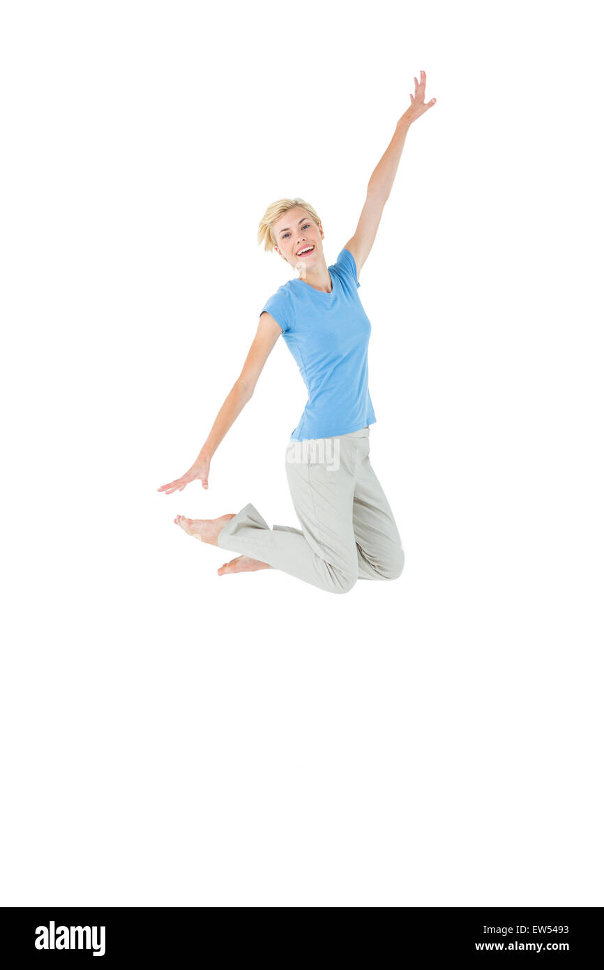 Cheerful blonde woman jumping Stock Photo