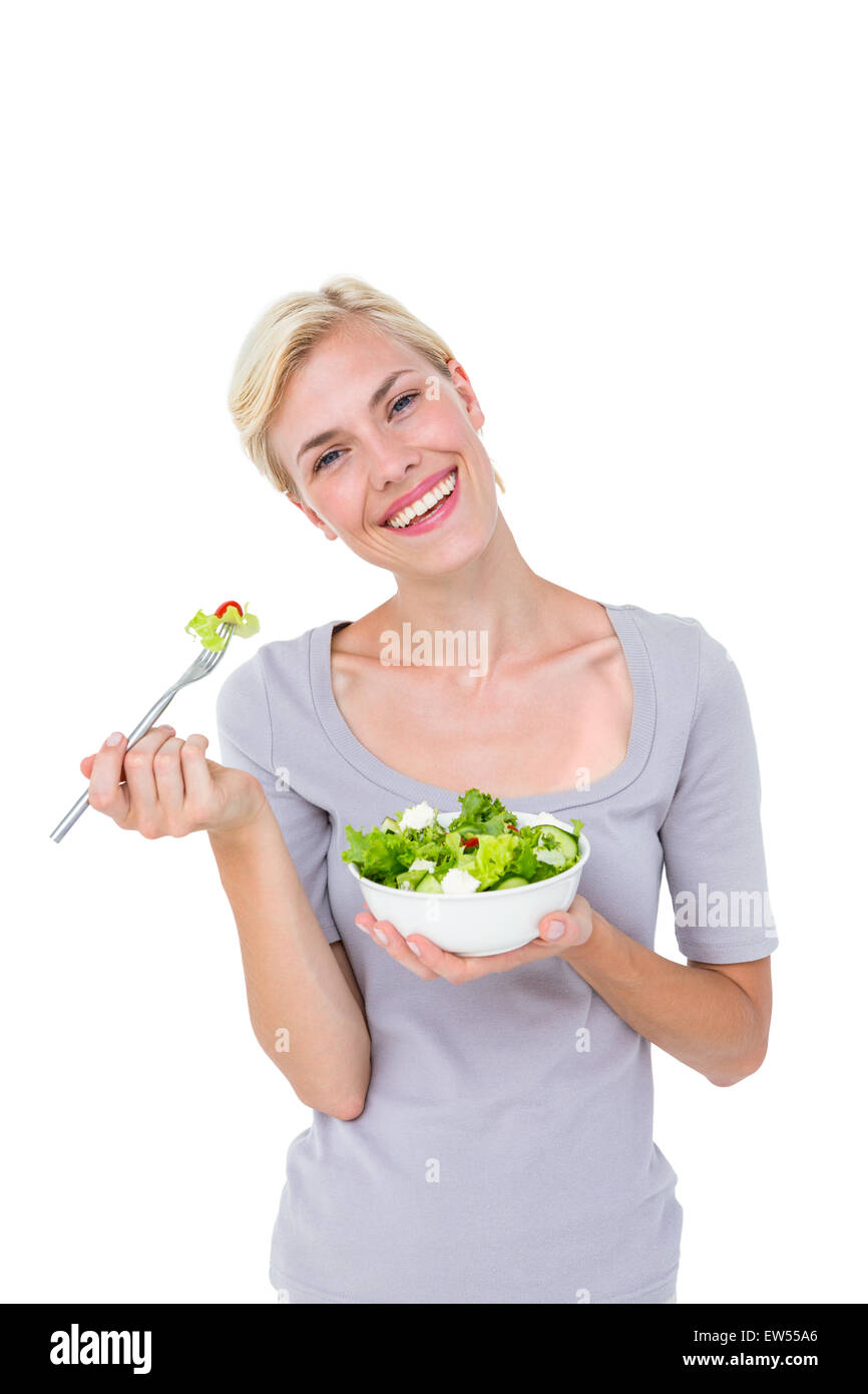 Happy blonde woman holding bowl of salad Stock Photo
