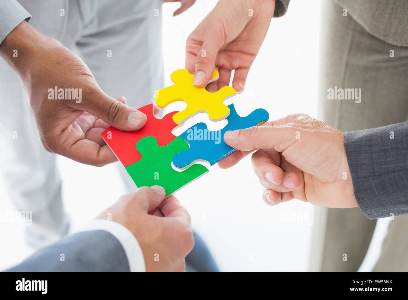 Business colleagues holding piece of puzzle Stock Photo