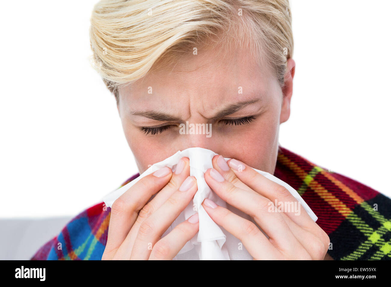 Sick blonde woman blowing her nose Stock Photo