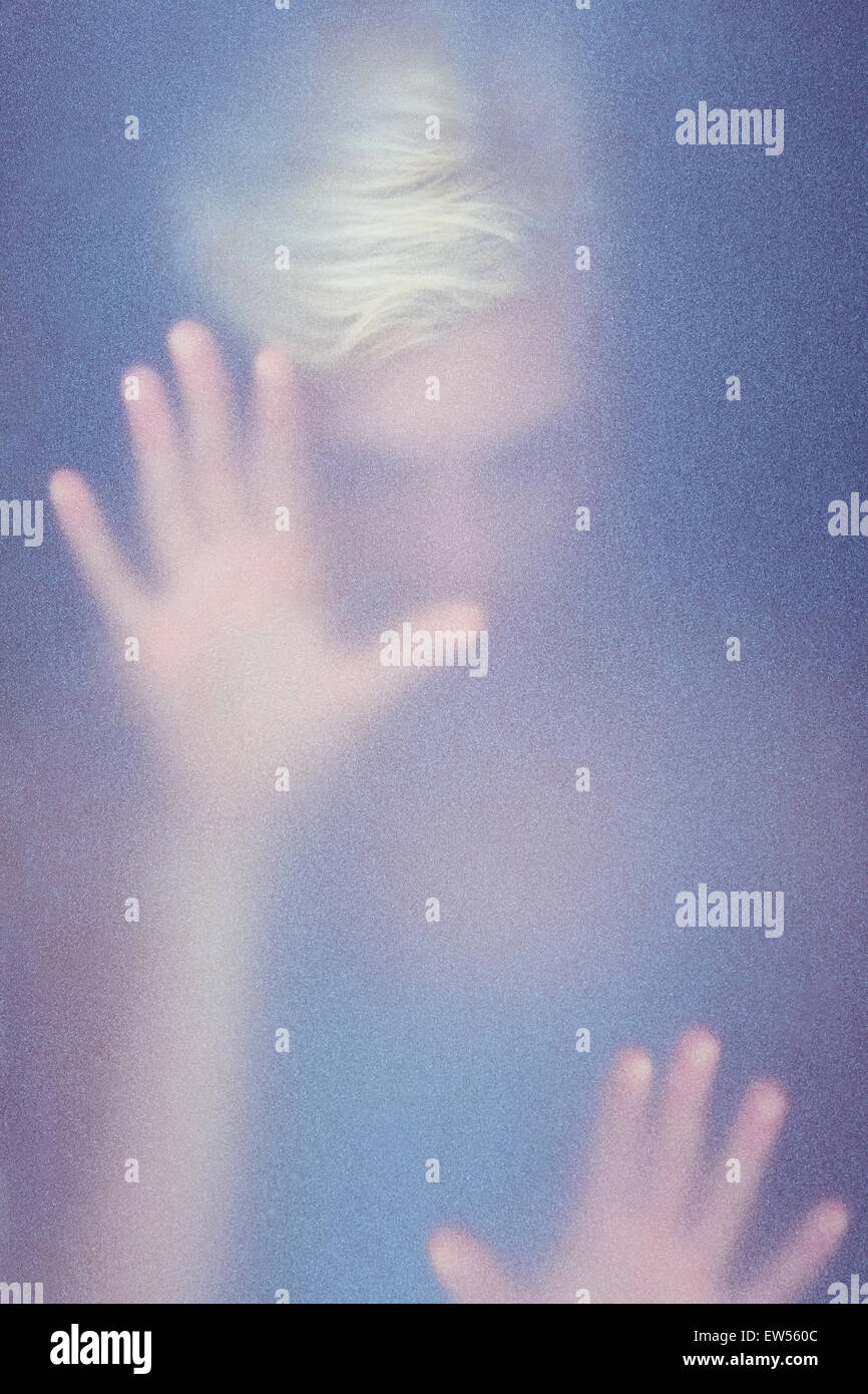 Blonde woman touching frosted glass Stock Photo