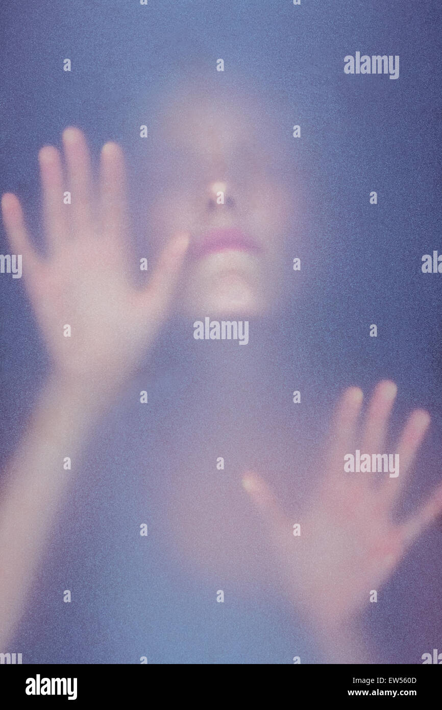 Blonde woman touching frosted glass Stock Photo