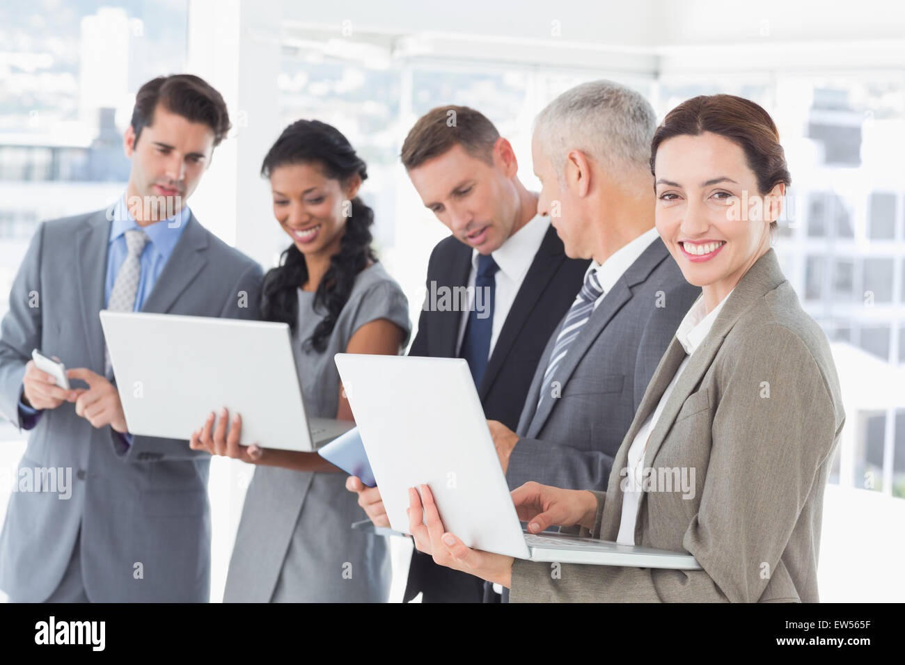 Business colleagues showing their multimedia devices to each other Stock Photo