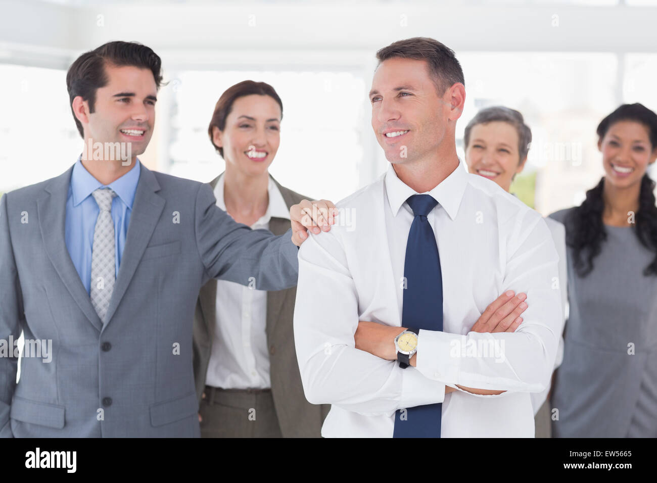 Business people congratulating their colleague Stock Photo