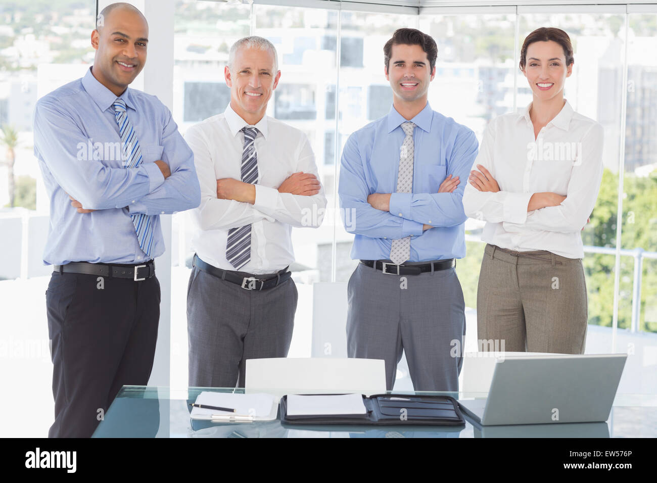 Business team smiling at camera arms crossed Stock Photo