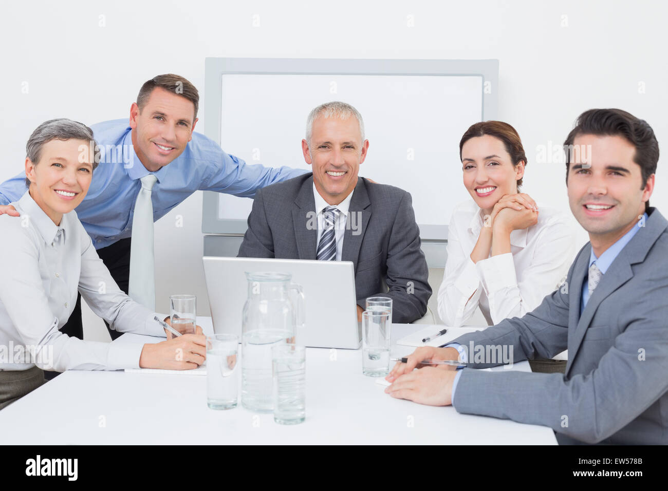 Business team working happily together on laptop Stock Photo