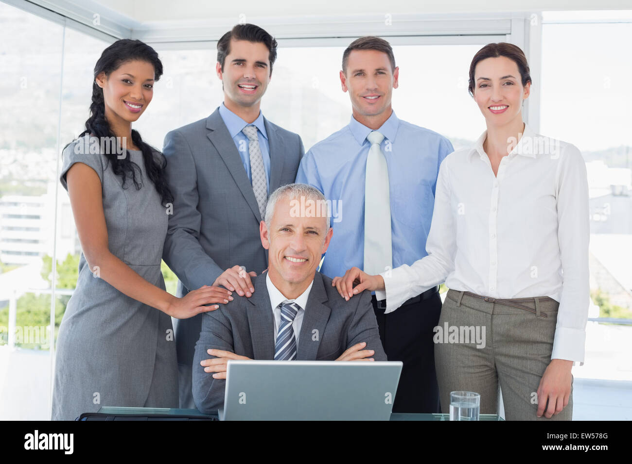 Smiling business team looking at camera Stock Photo - Alamy