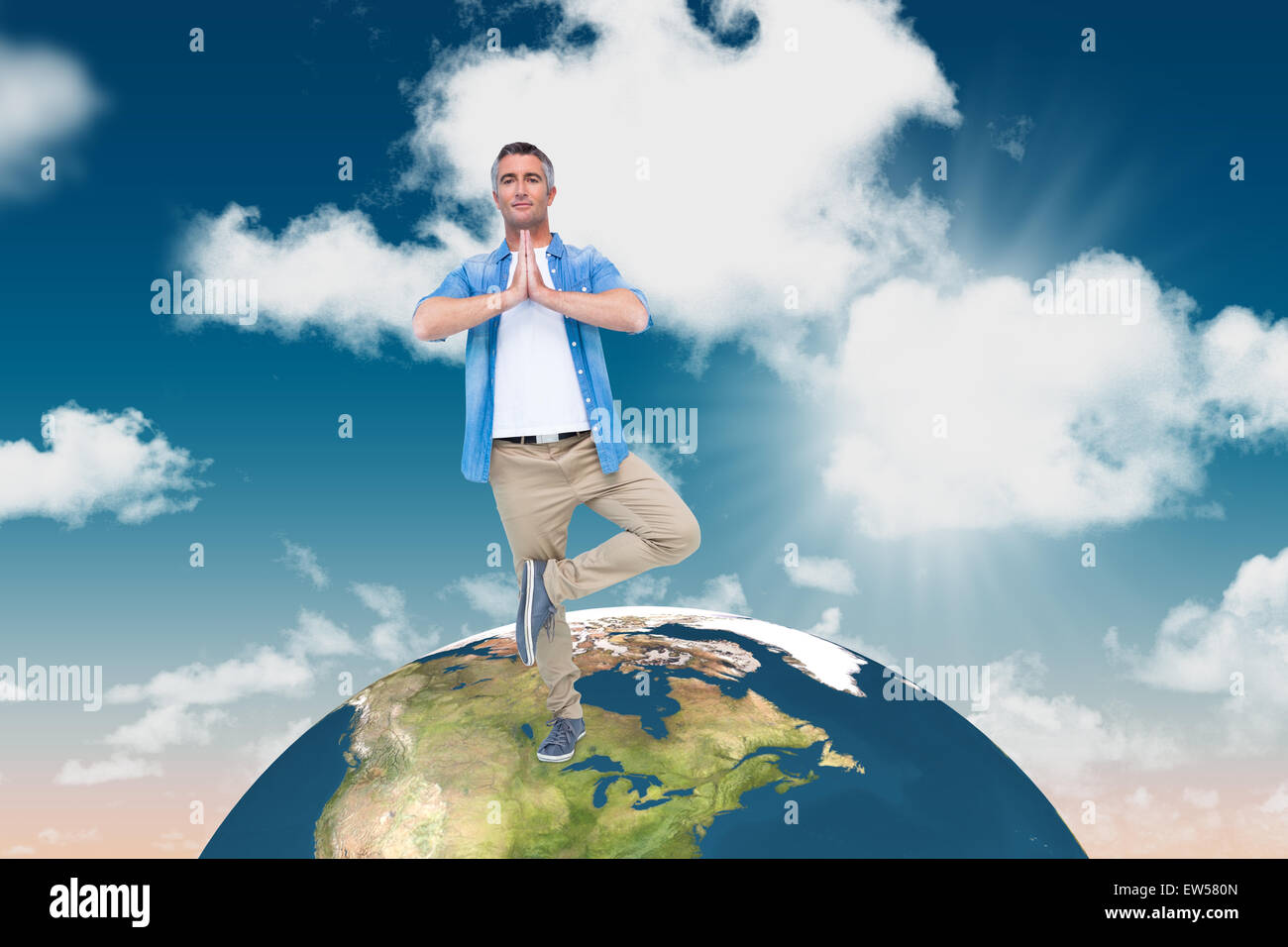 Composite image of man with grey hair in tree pose Stock Photo