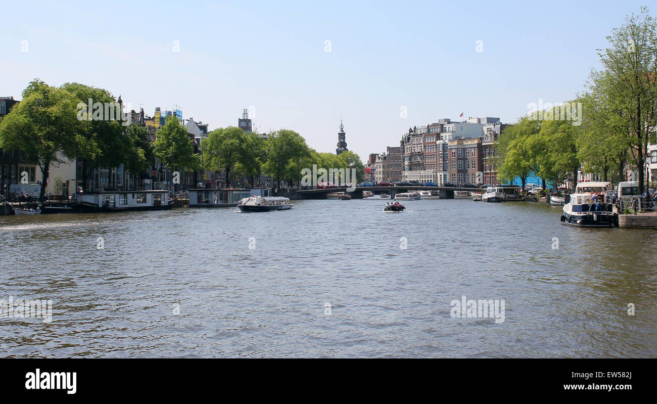 Ships and canal boats on the wide Amstel river  in Amsterdam, The Netherlands, corner of Amstel river and Zwanenburgwal Stock Photo