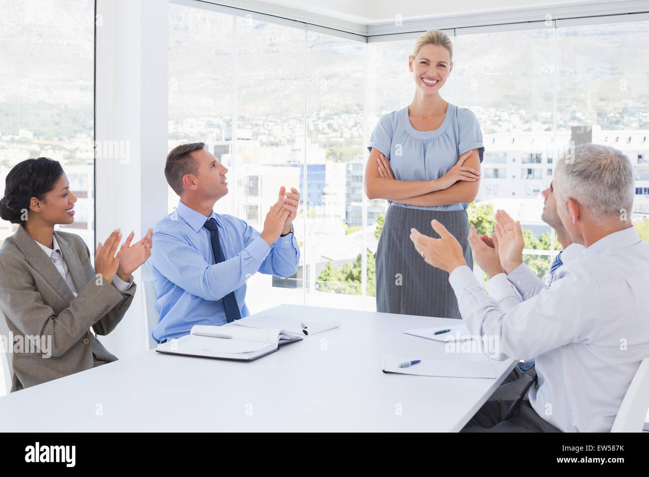 Business team applauding their colleague Stock Photo
