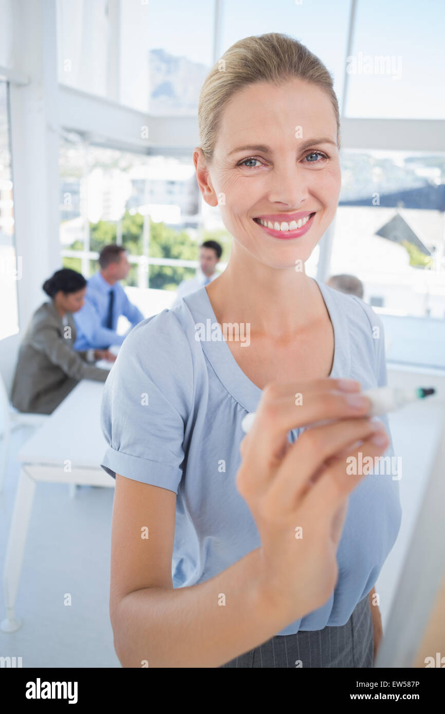 Businesswoman writing brainstorming ideas on board Stock Photo