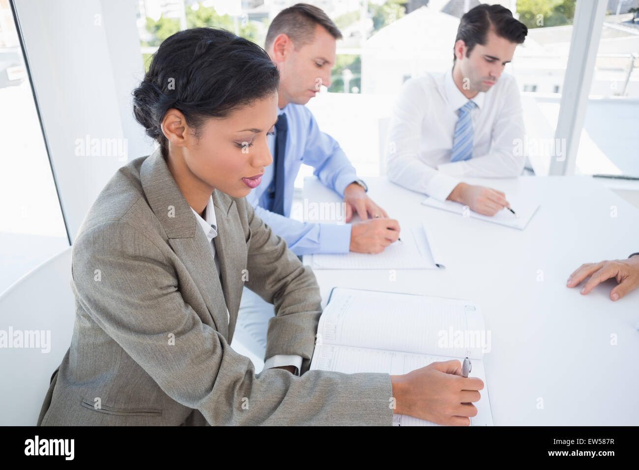 Business team writing brainstorming ideas in their notepad Stock Photo