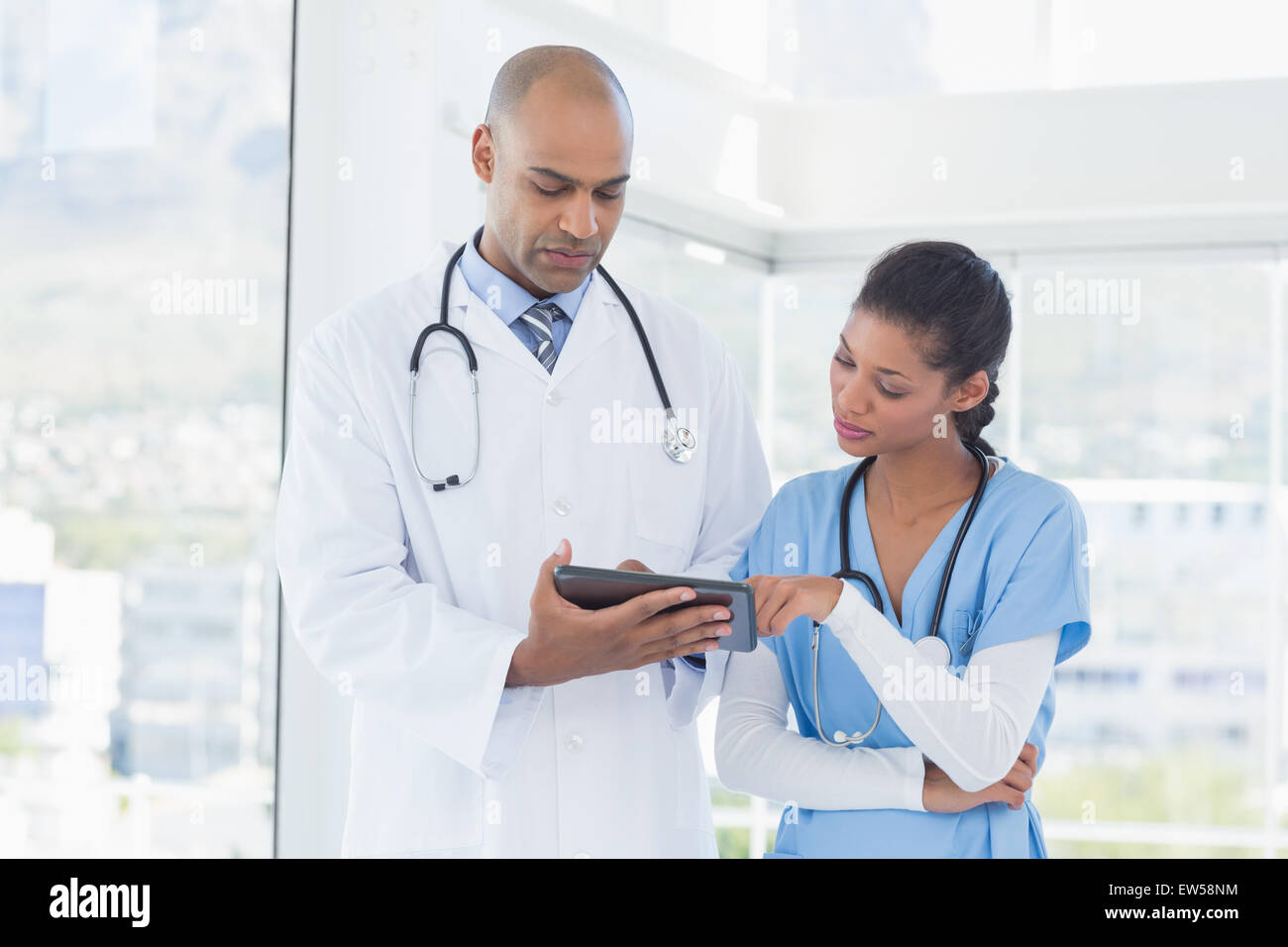 Smiling doctors working with tablet together Stock Photo