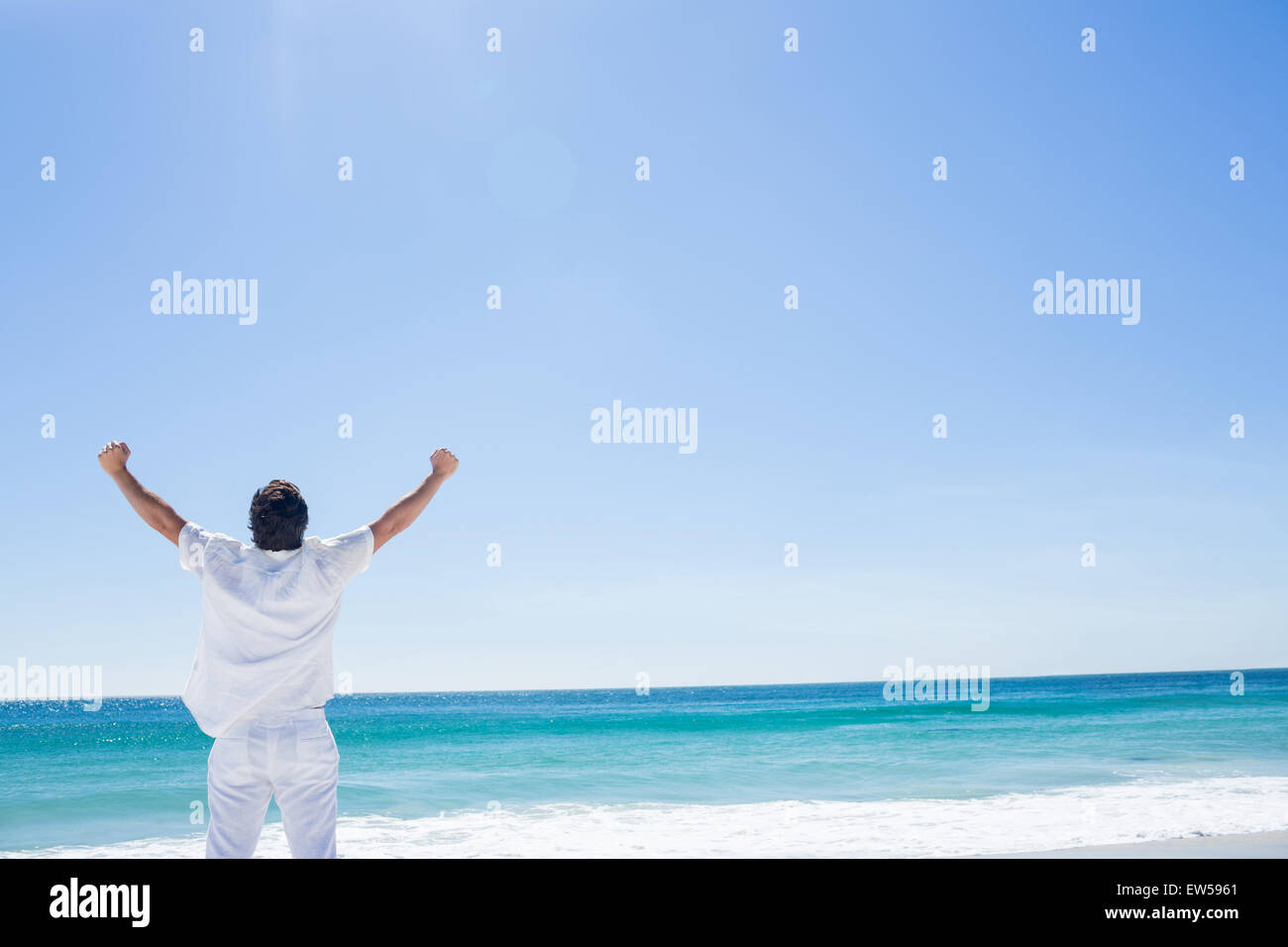 Man stretching his arms in front of the sea Stock Photo