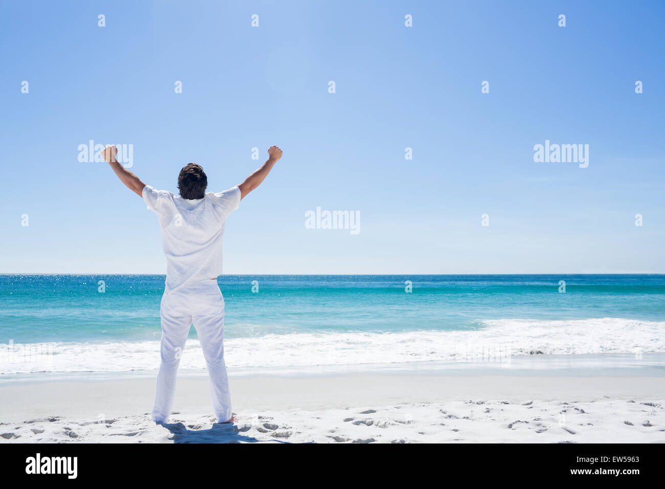 Man stretching his arms in front of the sea Stock Photo