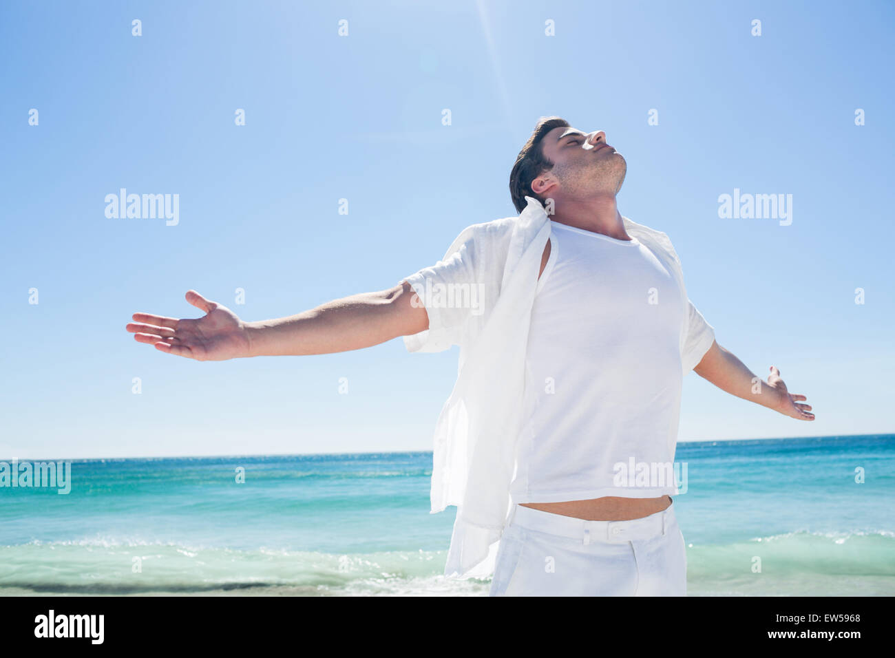 Man stretching his arms in front of the sea Stock Photo