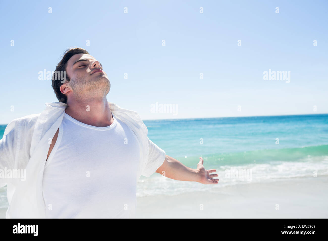 Man stretching his arms in front of the sea Stock Photo