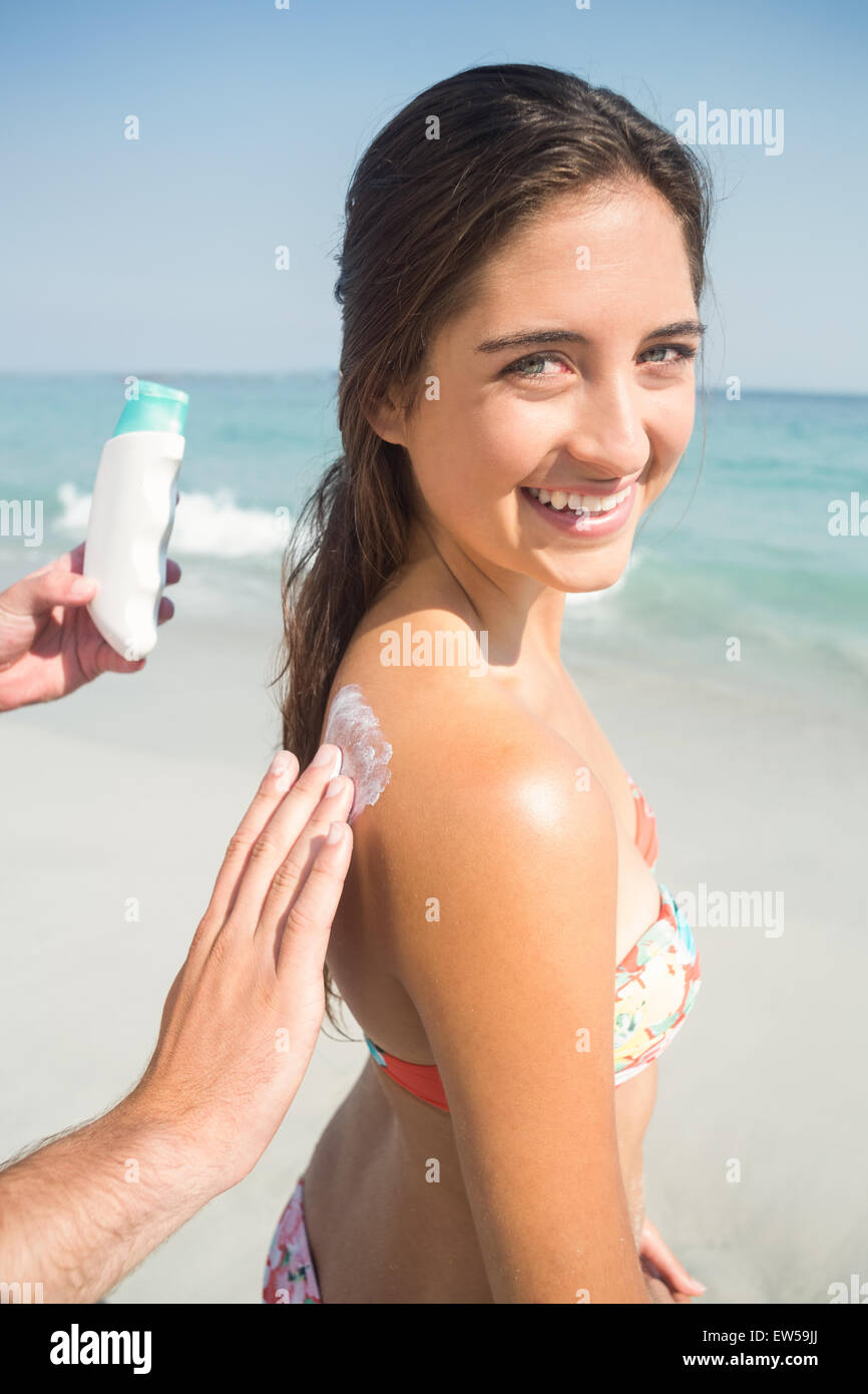 Man putting sun tan lotion on his girlfriend Stock Photo