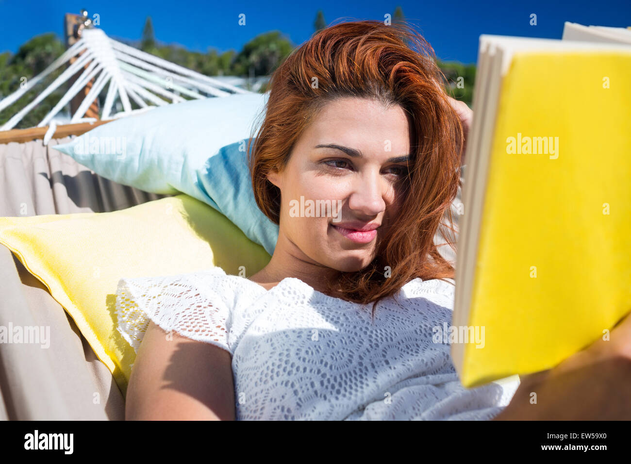 Brunette reading a book while relaxing in the hammock Stock Photo - Alamy